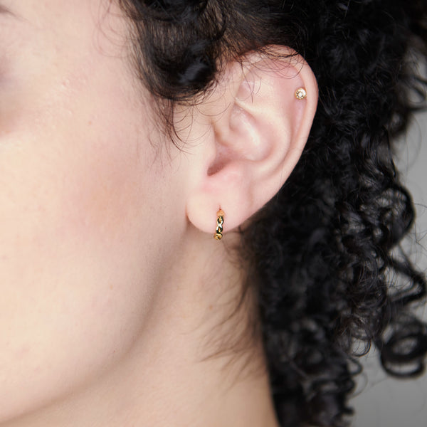 A Woman Wearing Torus Mini Twist Hoop Earrings