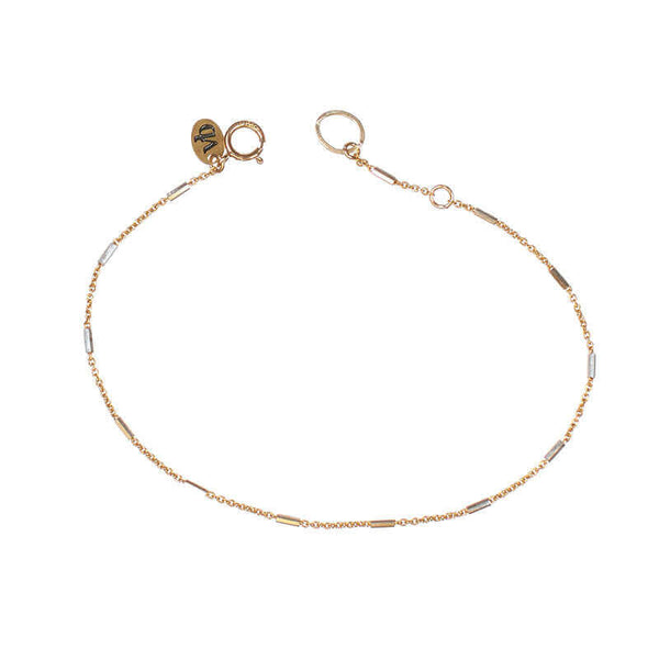 Delicate gold chain bracelet, with silver rectangular bead accents, clasp open.