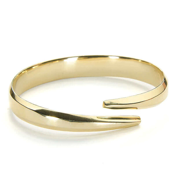 Heavy cuff bracelet with chamfered edges and overlapping ends, in polished brass.