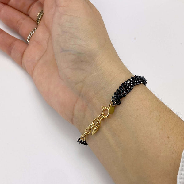 Close-up of bracelet with 3 twisted black oxidized chain showing gold links and clasp.