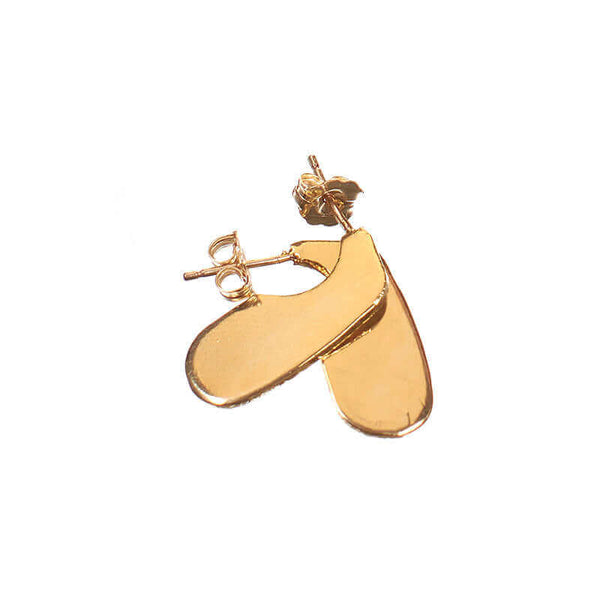 Pair of flat gold earrings on a post, with unique squared oval shape, on laid overlapping.