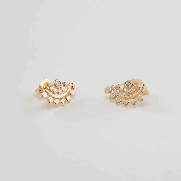 Pair of fan-shaped gold earrings with lace pattern, inset with small diamond, shown facing in.