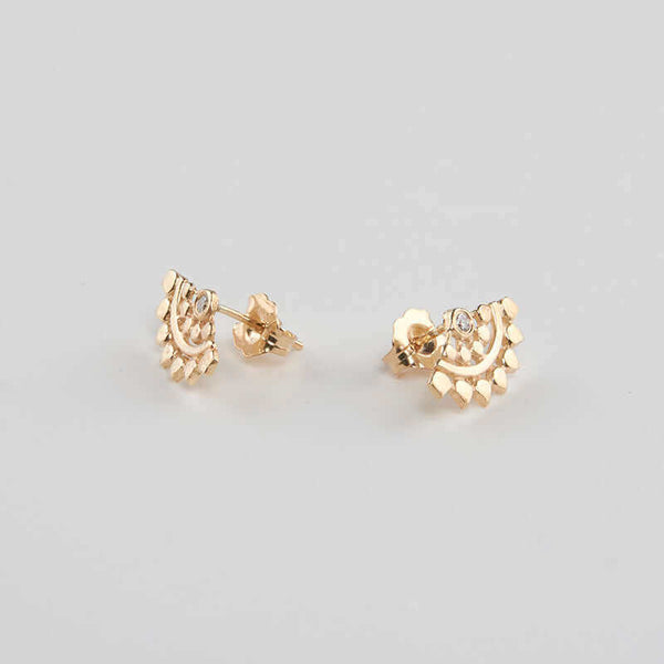 Pair of fan-shaped gold earrings with lace pattern, inset with small diamond, shown facing out.