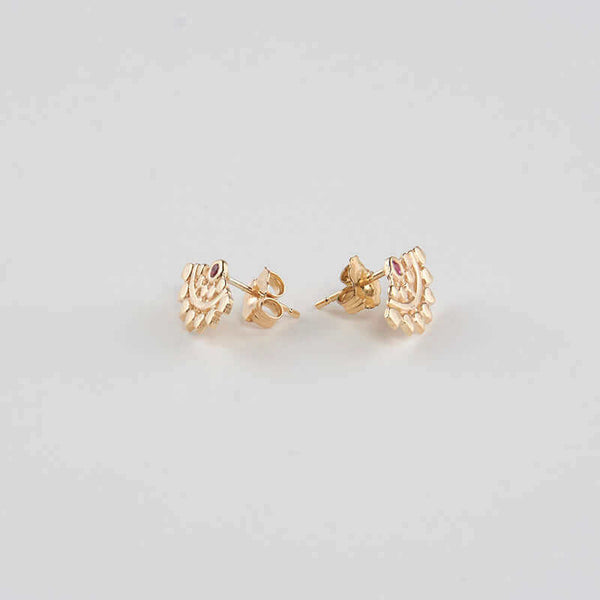 Pair of fan-shaped gold earrings with lace pattern, inset with small ruby, shown facing out.