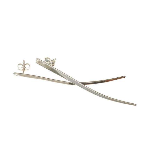 Pair of silver spike earrings, flat spike with a slight curve at tip, laid overlapping.