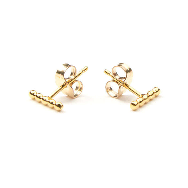 Pair of gold beaded bar earrings on earpost, facing out.