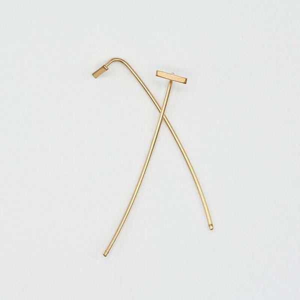 Pair of gold bar threader earrings with wire bar extending down, laying overlapped.