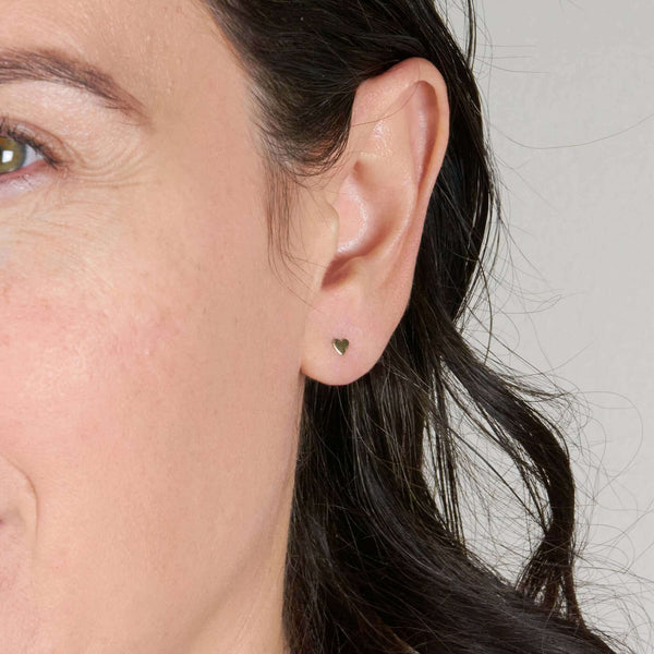 A Woman Wearing Cora Heart Stud Earrings on Pierced Ear