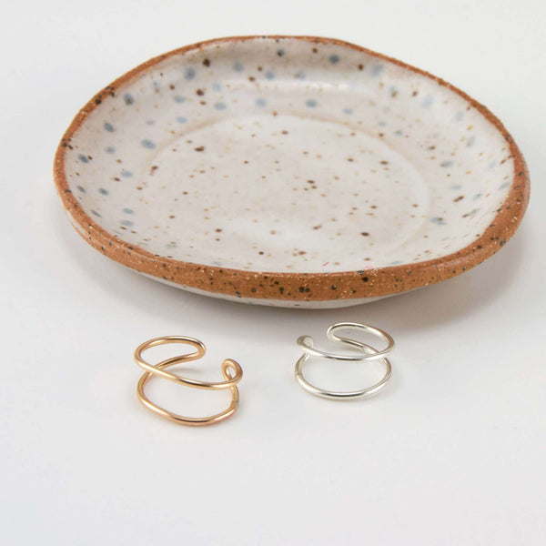 A Pair of  Ear Cuff Earrings  Displayed  near a Marble Plate