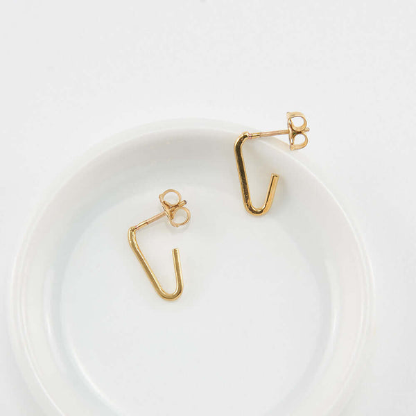 Pair of gold bent angle earrings on posts.