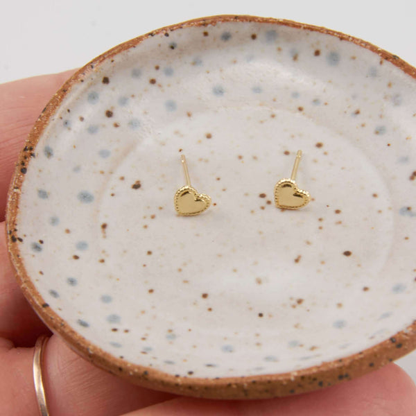 Pair of Herta Heart Stud Earrings Displayed on a Marble Plate