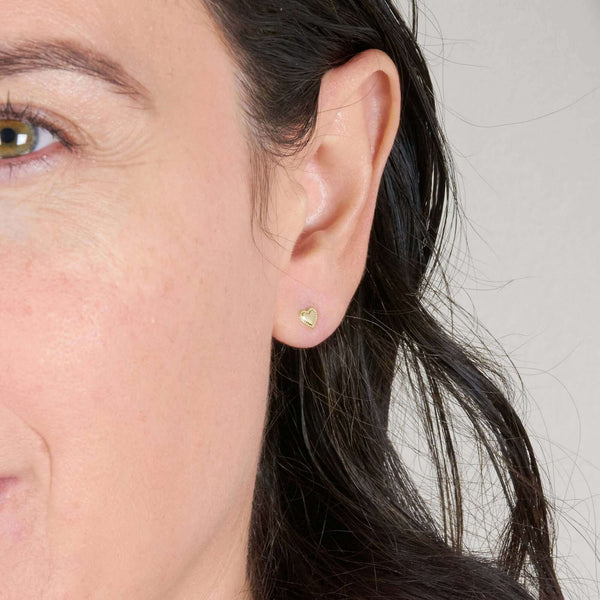 A Woman Wearing Herta Heart Stud Earrings on Pierced Ear