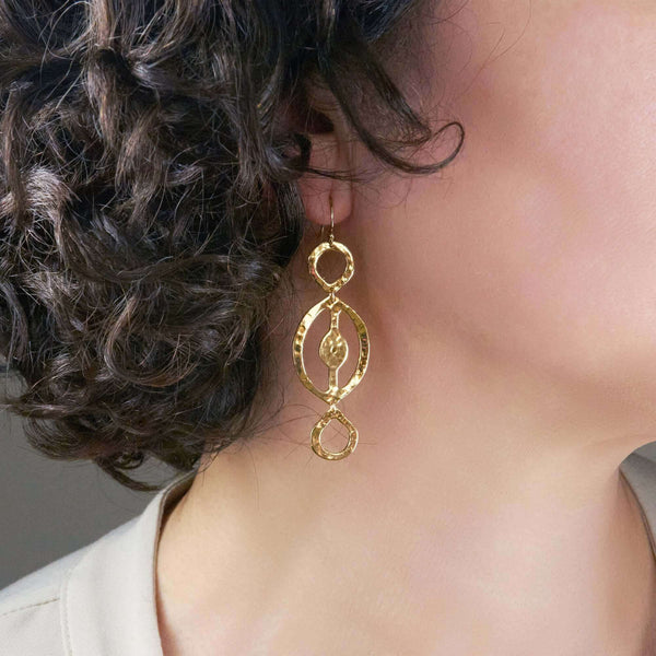 A Woman Wearing Itza Hammered Dangle Earrings