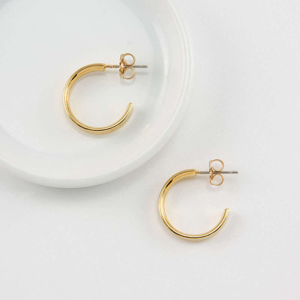 Pair of gold open hoop earrings on posts.