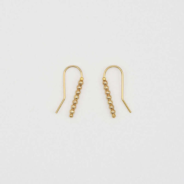 Pair of small gold wire earrings with gold beads.