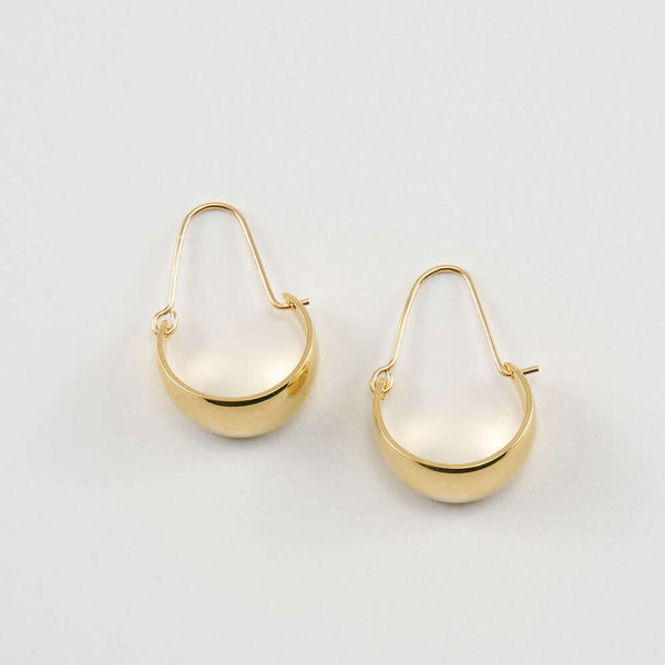 Pair of gold convex curved hoop earrings.