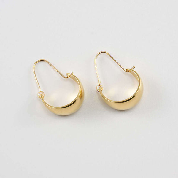 Pair of gold convex curved hoop earrings.