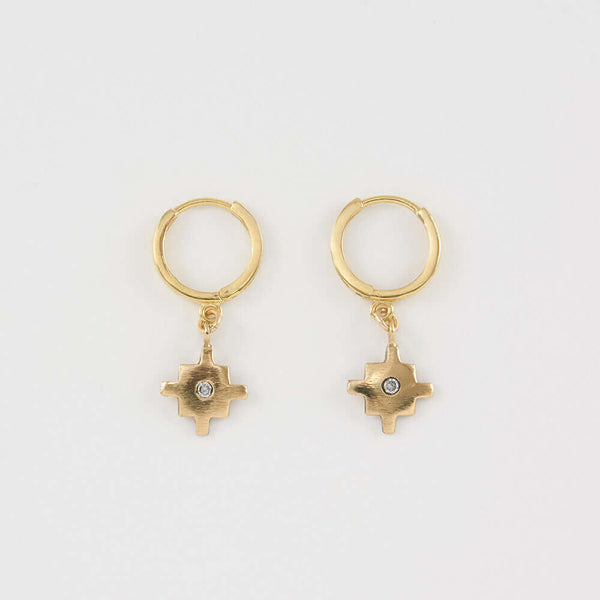 Pair of gold native motif cross earrings on hoop clasp.