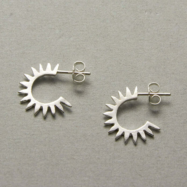 Pair of cast curved spiky silver earrings on posts.