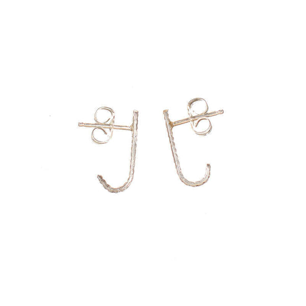 Pair of silver earrings, curved spike with serrations on posts that hooks around earlobe.