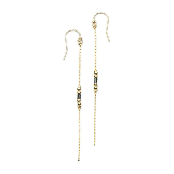 Pair of gold earrings, gold chain with black bead details.