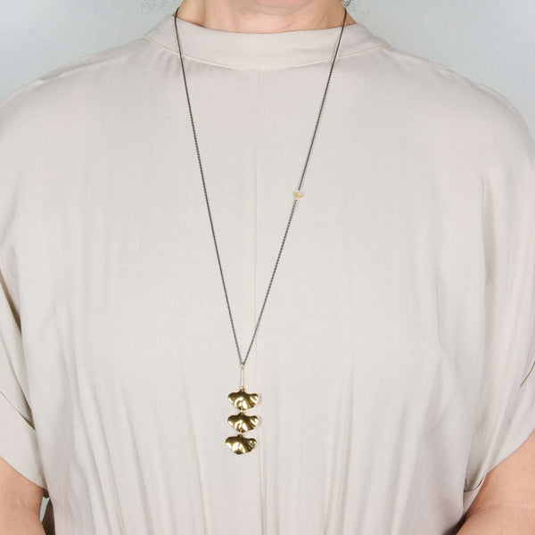 A man wearing a long Adele Leaf Pendant Necklace