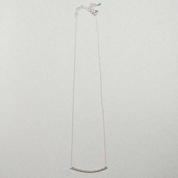 Close-up of silver chain necklace with curved beaded bar pendant, full length showing clasp.