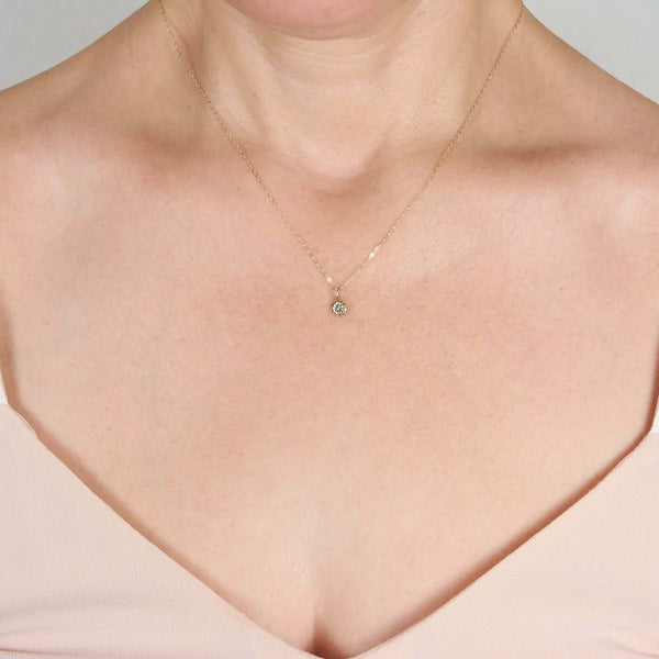 A Woman Wearing Delia Tiny Flower Pendant Necklace
