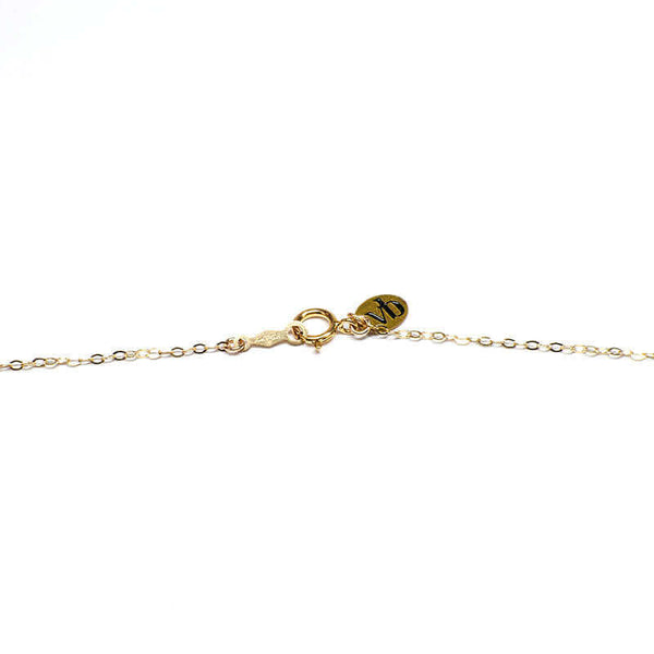 Clasp detail of delicate gold chain necklace.