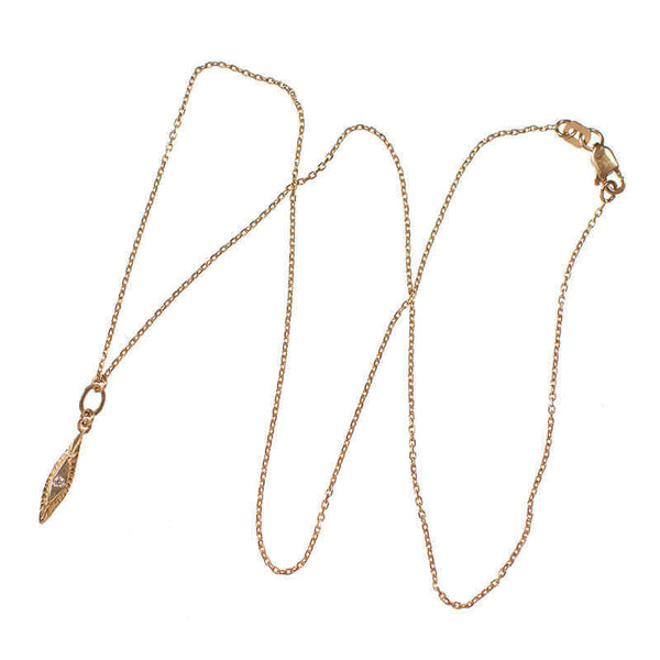 Delicate gold necklace with small elongated diamond shaped gold pendant with inset diamond.