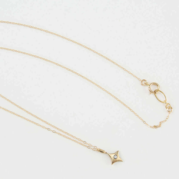 Delicate gold chain necklace with 4 point gold star pendant with inset diamond..