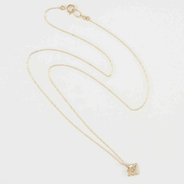 Delicate gold chain necklace with gold native motif cross pendant with inset diamond.