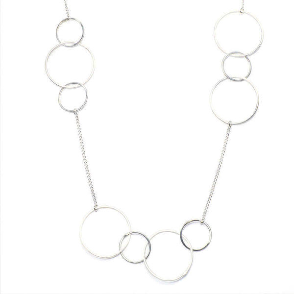 Close-up of silver necklace, groups of gold hoops on gold chain.