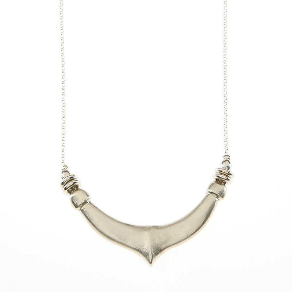 Close-up of delicate silver chain necklace with chunky hand cast organic curved pendant.