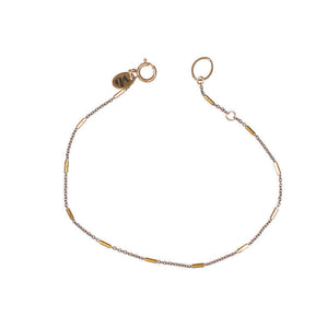 Delicate black chain bracelet, with gold rectangular bead accents, clasp open.