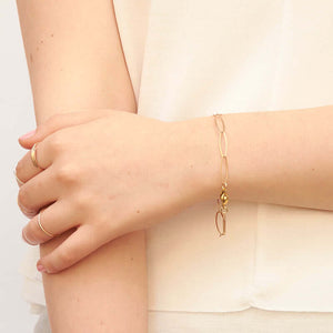 Detail of hand wearing bracelet of elongated gold links.