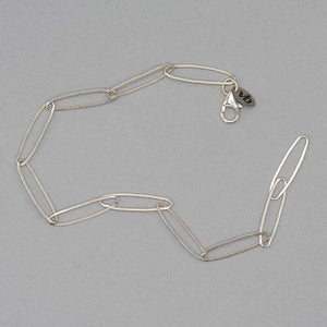 Bracelet of elongated silver links, unclasped.