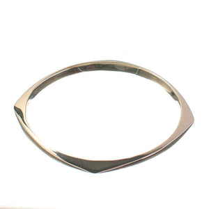 Silver bangle with rounded square shape, shown at low angle.