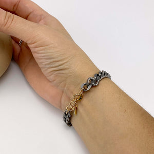Close-up of hand wearing chunky vintage curb chain bracelet showing clasp.