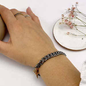 Close-up of hand wearing chunky vintage curb chain bracelet.