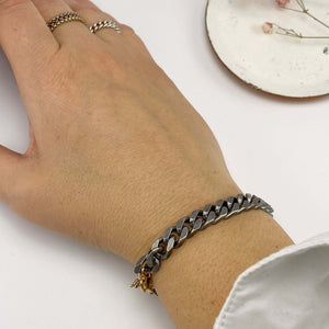 Close-up of hand wearing chunky vintage curb chain bracelet.