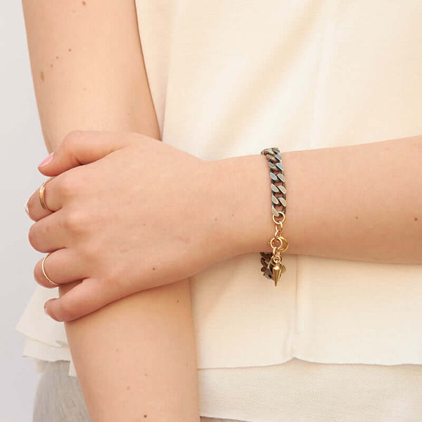 Close-up of crossed arm wearing chunky vintage curb chain bracelet.