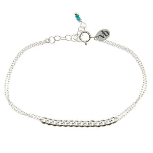 Delicate silver chain bracelet with curb chain detail at center, and tiny blue beads at clasp.
