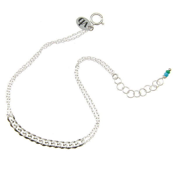 Delicate silver chain bracelet with curb chain detail at center, and tiny blue beads at clasp.