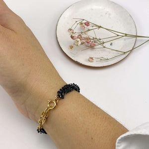 Close-up of bracelet with 3 twisted black oxidized chain showing gold links and clasp.