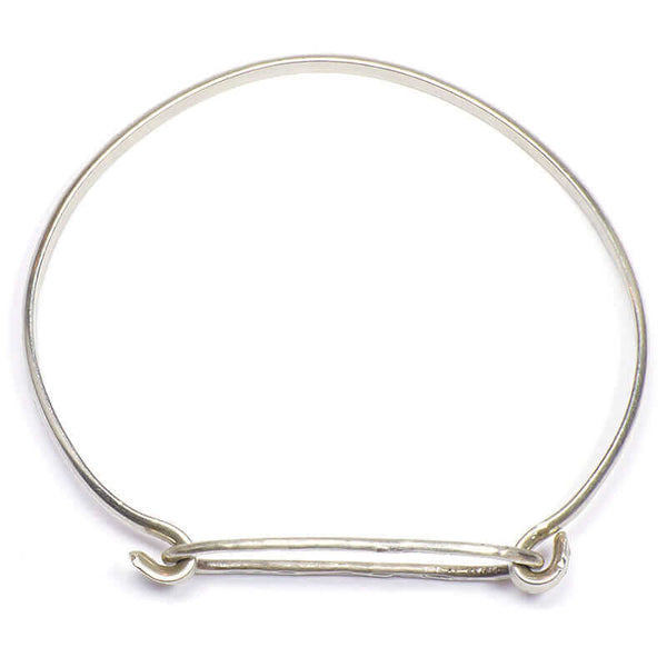 Simple bangle bracelet of silver hammered oval on silver cuff, shown from above.