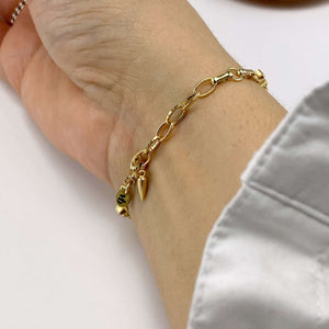 Close-up of hand wearing a chunky gold box chain bracelet, showing clasp.