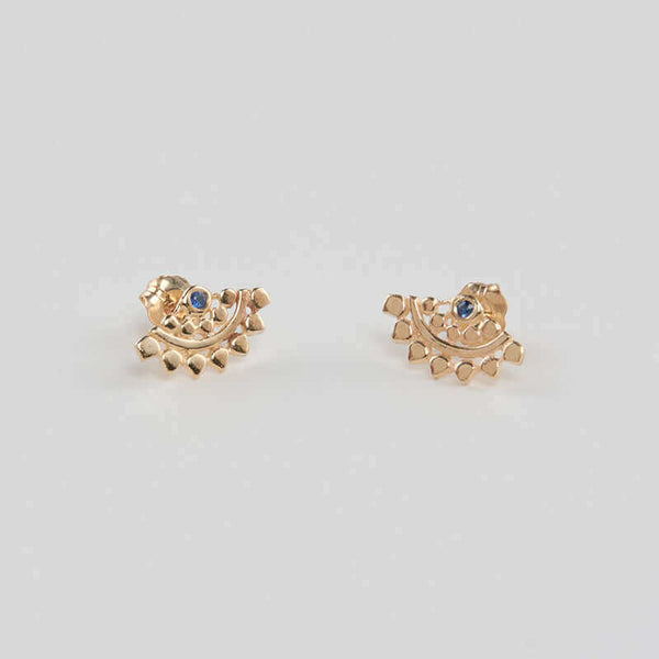 Pair of fan-shaped gold earrings with lace pattern, inset with small sapphire, shown facing in.