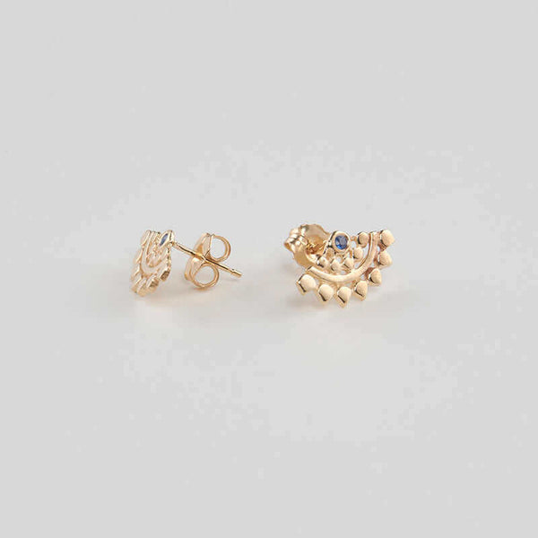 Pair of fan-shaped gold earrings with lace pattern, inset with small sapphire, shown facing out.