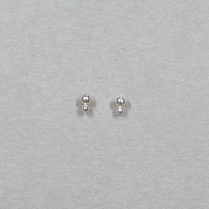 Small silver earrings with two gold stacked beads on a post, shown from front.